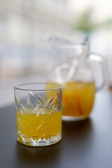 A pitcher of lemonade and a glass of lemonade in a summer cafe on the table
