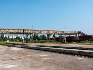 Fototapeta na wymiar Railroad station. Long iron footbridge across the railroad tracks.