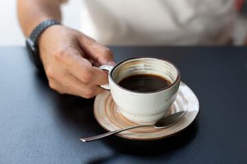 a man drinks black coffee in a summer cafe