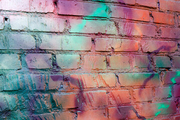 Art texture: a brick wall is painted with multi-colored spray paints. Photo of textures in the city.