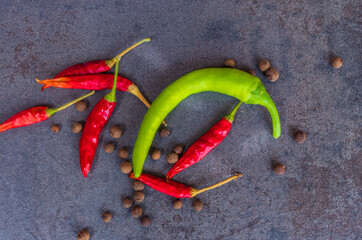 Hot peppers with spices on wooden table close up