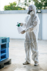 Disinfection specialist female in PPE suit performing public decontamination