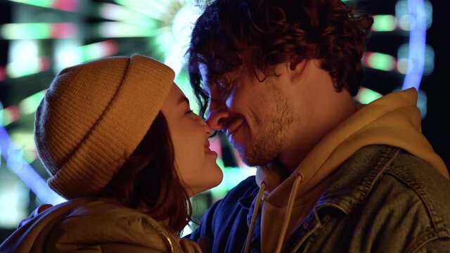 Lovely couple rubbing noses outdoor. Man and woman felling happy on city street.