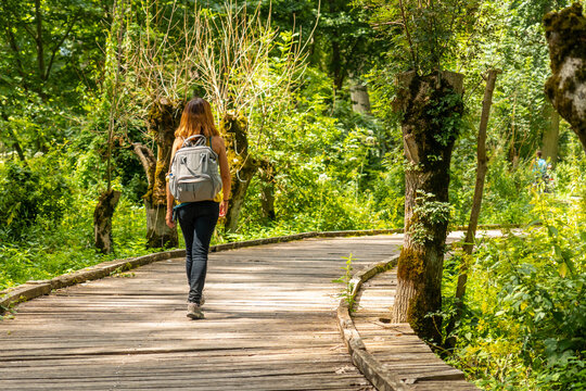 A young woman walking on the trek on the trail between La Garette and Coulon, Marais Poitevin the Green Venice, near the town of Niort, France