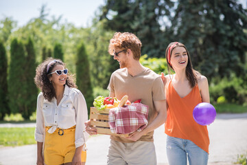 Three young people going on summer picnic