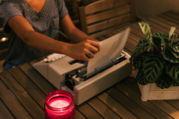 Caucasian teen girl changing the paper on a retro typewriter.