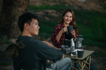 Young couple relax with coffee at nature park during camping