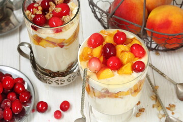 Dessert with ricotta, peach and cranberries on a white plate