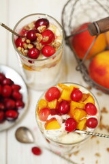 Dessert with ricotta, peach and cranberries on a white plate