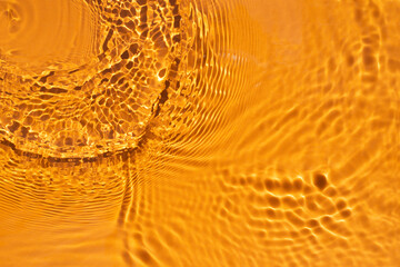 Banner or background for advertising cosmetics with orange water spills. Natural sunlight and...