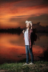 Young packpacker female standing with beautiful nature sunset