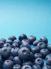 A bunch of blueberries on a blue background, super food, healthy eating concept, space for your text