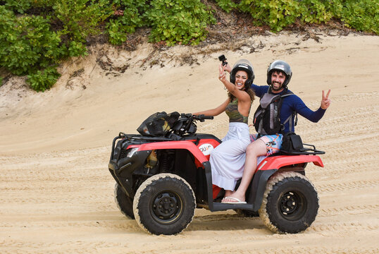 Natal, Rio Grande do Norte, Brazil - March 12 2021: Couple riding a quad on the maracajau promenade in rio grande do norte