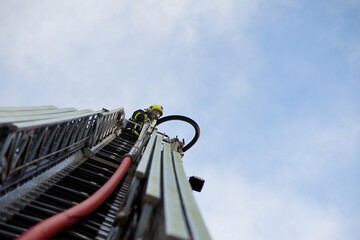 Firefighter in a basket of fire truck ladder

