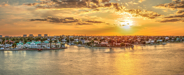 Fototapeta Golden Sky Over City Lights Across Factory Bay In Marco Island, Florida. obraz
