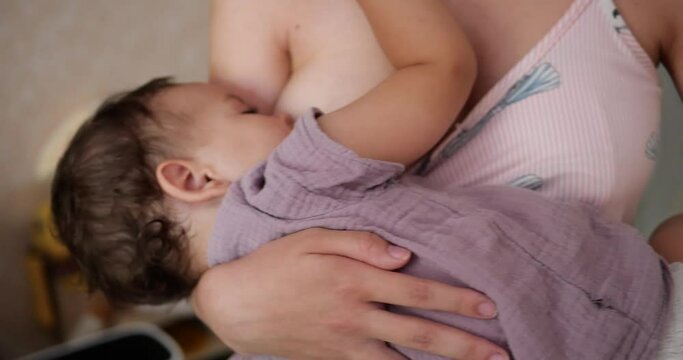 a small child sleeps peacefully on the mother's chest. mom shakes the baby in her arms