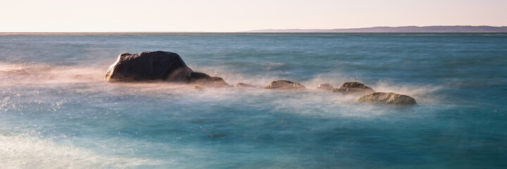 Fototapeta premium Seascape with ancient glacial rocks and steaming seawater on the Cape For the beach. Zen-like ocean view over the Martha's Vineyard in Massachusetts.