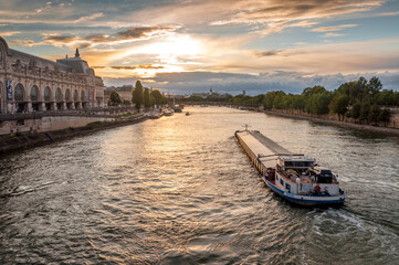 Transport fluvial sur la Seine vue du Pont Royal au crépuscule à Paris - obrazy, fototapety, plakaty