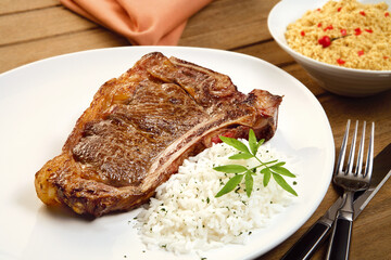 Prato com bisteca bovina grelhada acompanhada de arroz branco e farofa