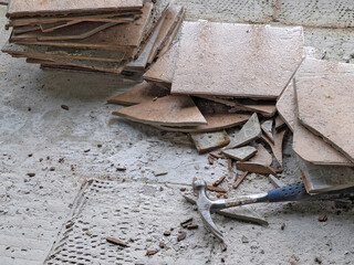 Hammer with broken ceramic floor tile on concrete