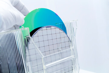 Silicon Wafers in storage box on table in clear room prepared for production of semiconductor foundry.