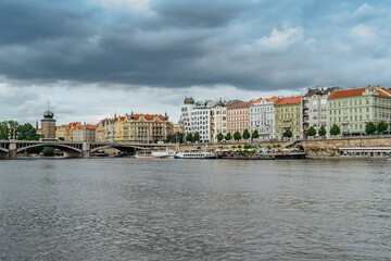 Obraz premium Prague, Czech Republic.Amazing view of famous Dancing House and Rasin Embankment.Riverfront colorful buildings,bridge over Vltava river,boats.Beautiful European cityscape.Tourist destination