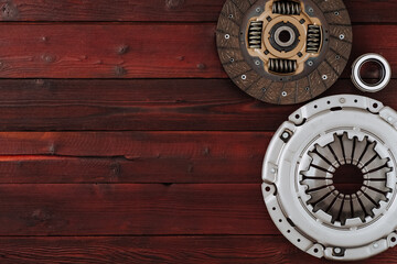 Automotive clutch mechanism, disc, basket and bearing for auto on a wooden background