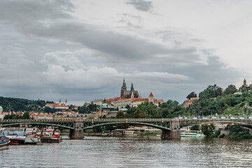 Scenic panorama of beautiful Prague Castle,Saint Vitus cathedral,Cechuv bridge over Vltava river.Famous tourist destination.Prague panorama on cloudy summer day.European cityscape urban travel concept
