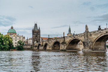 Charles Bridge,tourist boat on Vltava river,Prague, Czech Republic. Buildings and landmarks of Old town on summer day. Amazing European cityscape.Popular tourist destination.Colorful urban city scene