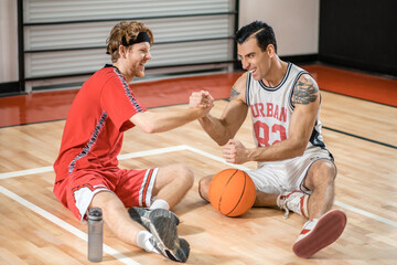 Fototapeta premium Men in sportswear resting after the basketball game and talking