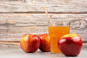 Apple juice and red apples on the table.