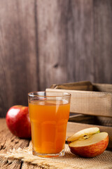 Apple juice and red apples on the table.