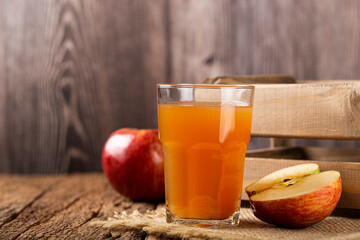 Apple juice and red apples on the table.