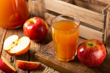 Apple juice and red apples on the table.