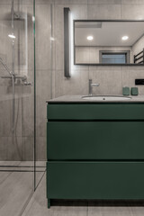 Modern minimalist bathroom interior design with grey stone tiles and green furniture