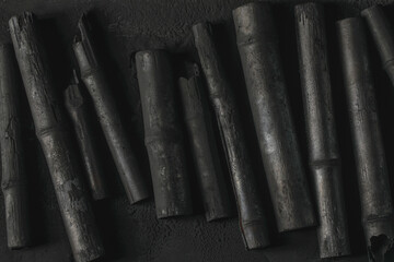 Bamboo charcoal  stick on coal powder black background..Powerful water purifier