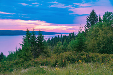 Evening landscape, beautiful view from the hill to the pink sunset, in the distance below you can...