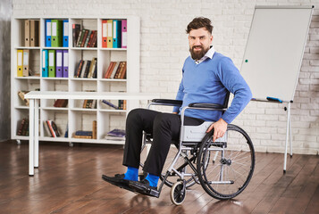 Smiling disabled businessman sitting in a wheelchair at his office