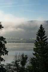 Fototapeta na wymiar Early morning view over Lac de Joux, Switzerland, towards the misty Jura mountains during sunrise