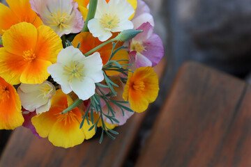 Beautiful bouquet of orange, pink and white flowers in a vase. Wild California poppy. Background photo.