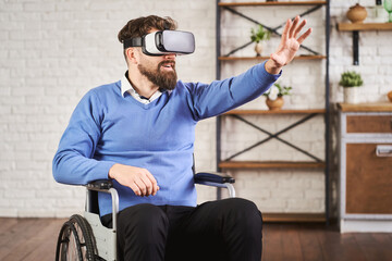 Portrait of a man sitting on a wheelchair and using a VR headset