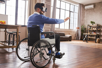 Man with disability sitting in a wheelchair and using a VR headset
