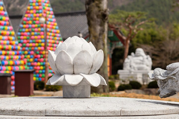 Lotus statue in a buddhist temple Songgwangsa, colorful lantern towers on background, South Korea