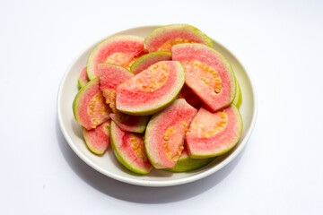 Fresh pink guava in white plate on white background.