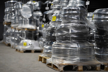 Black plastic pipes wrapped in foil on a pallet in a warehouse. Pipe packaging ready for...