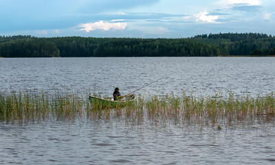 Fototapeta premium Fisherman on boat at lake
