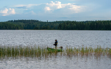 Obraz na płótnie Canvas Fisherman on boat at lake