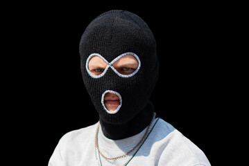 Closeup headshot of criminal wearing black balaclava and hoodie looking at camera, copy space, isolated over black background. crime and violence, drugs, fashion, rap, rapper new school.