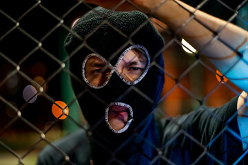 young man in balaclava looking at camera and blow smoke out. crime and violence, drugs, fashion, rap, rapper new school, style in night city. - obrazy, fototapety, plakaty