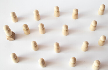 The child was lost in the crowd. A crowd of wooden figures of people surround a lost child.